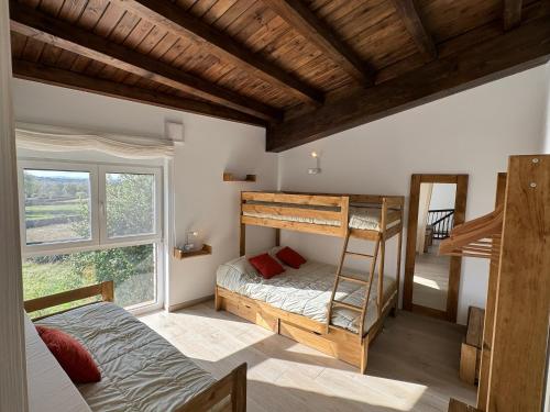 a bedroom with two bunk beds and a window at Alameda Amable in La Zarza de Pumareda
