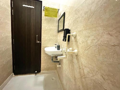 W łazience znajduje się umywalka i lustro. w obiekcie Kashyap Inn Hotel w mieście Noida