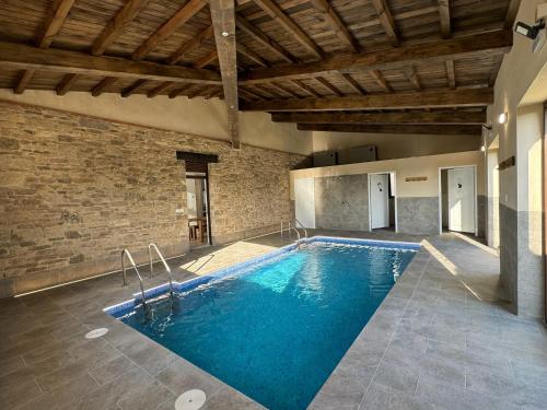 a swimming pool in a building with a brick wall at Alameda Amable in La Zarza de Pumareda