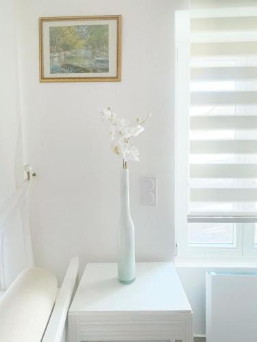 a vase with white flowers sitting on a table at Place Sainte Marguerite in Provins