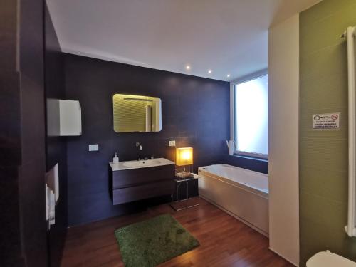 bagno con lavandino, vasca e specchio di ZagHouses - sea view apartments in Sicily ad Agnone Bagni