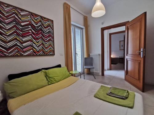 una camera da letto con un letto con un cuscino verde di ZagHouses - sea view apartments in Sicily ad Agnone Bagni