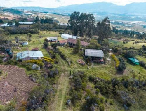 an aerial view of a farm with buildings and trees at Finca la Riverita in Sutamarchán