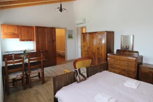 1 dormitorio con cama, mesa y cocina en Casa Vilma, en Paderno del Grappa