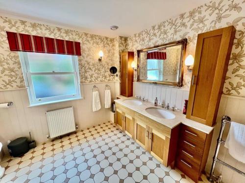 a bathroom with a sink and a mirror at Osmund House, Salisbury Sleeps up to 19 in Salisbury