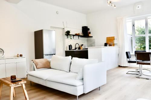 a living room with a white couch and a kitchen at Boutique Appartement Oost in Nijmegen