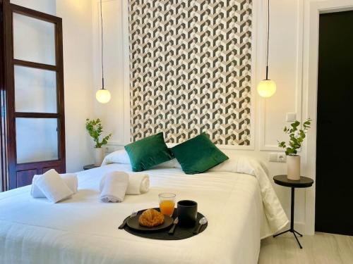 a white bed with a tray of food on it at La Suite de Anabel in Córdoba
