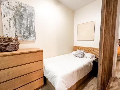 um quarto com uma cama e uma cómoda em madeira em apartamento muy próximo a Valencia em Burjasot