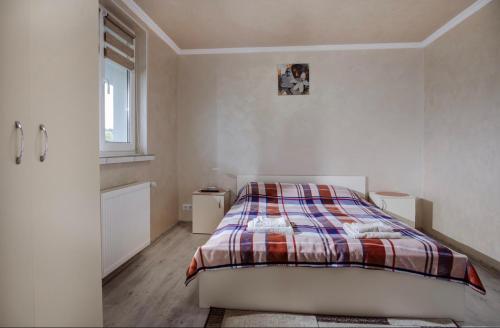een witte slaapkamer met een bed en een raam bij Апарт-готель Уляна in Skhidnitsa