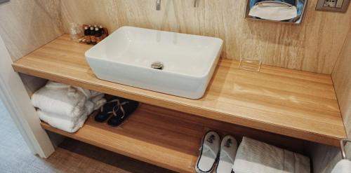 a bathroom sink sitting on top of a wooden counter at Hotel Le Soleil in Lido di Jesolo