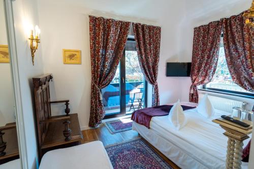 a bedroom with a bed and a window at Casa Din Bran - Inn Cuisine in Bran