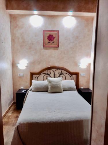 a bedroom with a large bed with two night stands at Hostal segovia adults only in Segovia
