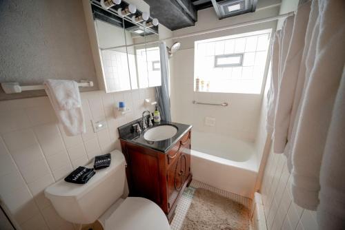 La salle de bains est pourvue de toilettes, d'un lavabo et d'une baignoire. dans l'établissement Bootlegger House Sleeps 10-20 Free TV & Parking, à Chicago