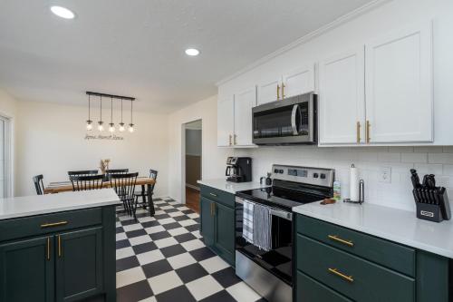 a kitchen with green cabinets and a checkered floor at NEW Dragster Dream House 3BD2BA Game Room in Bluff City