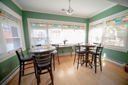 a dining room with two tables and chairs and windows at Bootlegger House Sleeps 10-20 Free TV & Parking in Chicago