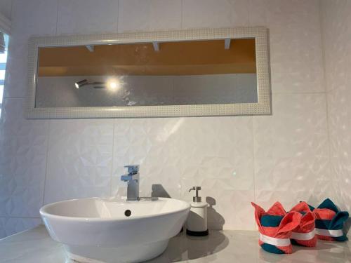 a bathroom with a white sink and a mirror at Story Villa 2 Bedrooms with Mountain & Ocean View in Canaries