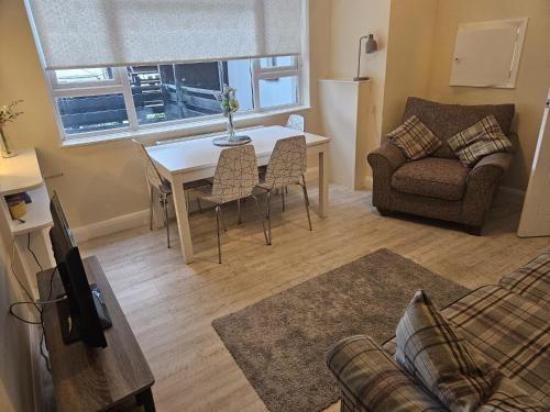 a living room with a table and a couch at Leigh-on-Sea Retreat - 2 Bedroom Apartment in Leigh-on-Sea