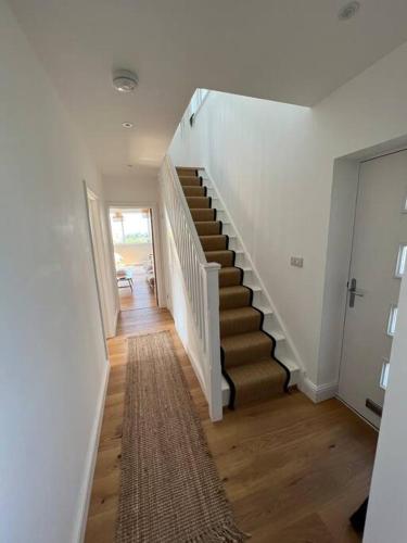 a hallway with a staircase in a house at Stunning home with magnificent views in East Devon in Exeter