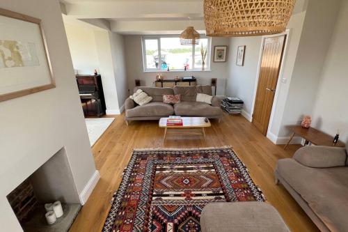 a living room with a couch and a rug at Stunning home with magnificent views in East Devon in Exeter