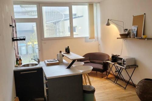 a kitchen with a table and a chair in a room at Le zen - Appartement avec terrasse in Vertou