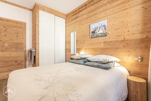 a bedroom with a bed and wooden walls at Côté-Bourget, 2 apparts 10 personnes et 4 personnes, proche des stations La Norma Aussois in Villarodin-Bourget