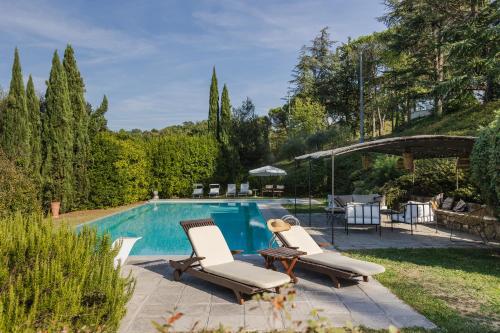 una piscina con 2 tumbonas y una mesa en Monteaperto, en Barberino di Mugello