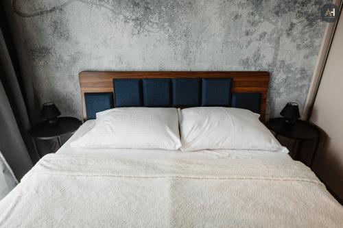 um quarto com uma cama com uma cabeceira azul em AH Albelli em Košice