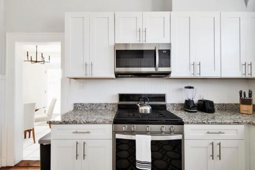 a kitchen with white cabinets and a stove top oven at Casa Alma in Tampa