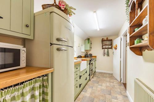 a kitchen with a refrigerator and a microwave at Ships Timbers in Winterton-on-Sea