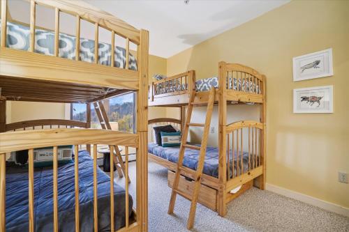 a bedroom with two bunk beds in a house at Gorgeous views, tastefully decorated Ski on ski off 3 bedroom condo, with sports center access Lodges 303 in Killington