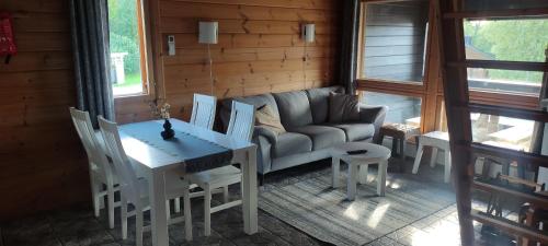 a living room with a couch and a table and chairs at Himos, Areenan alue in Jämsä