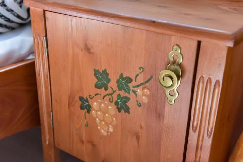 a wooden cabinet with a grape design on it at Borács Winedégház in Bogács