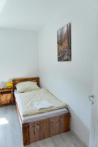 a bed with a wooden frame in a room at Borács Winedégház in Bogács
