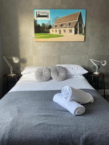 a bedroom with a bed with towels and a house at The Angler, Oakham in Oakham