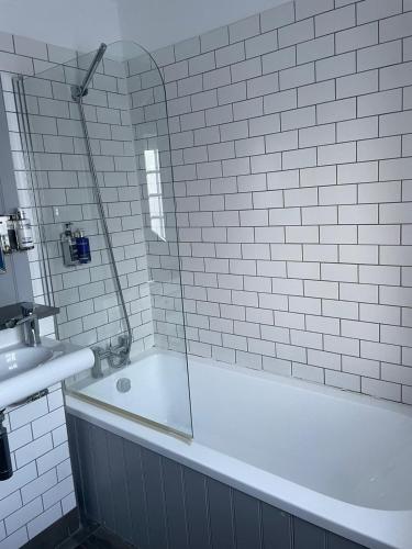 a white bathroom with a tub and a sink at The Angler, Oakham in Oakham