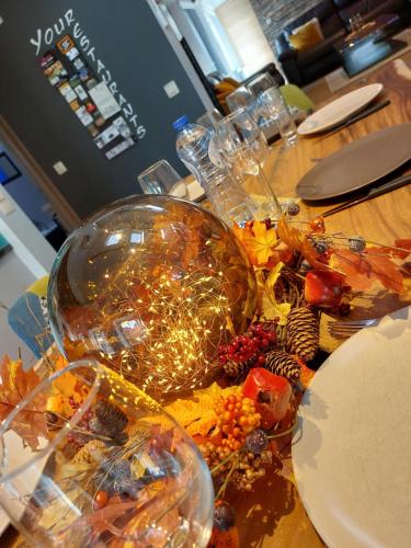 a table with christmas lights in a glass bowl at La Renaissance 1&2 high standing guest house in Herve