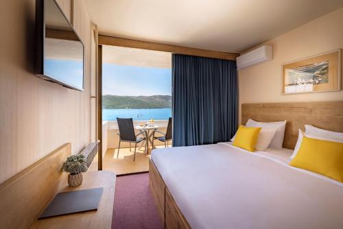 a hotel room with a bed and a view of the ocean at Arkada Hotel in Stari Grad