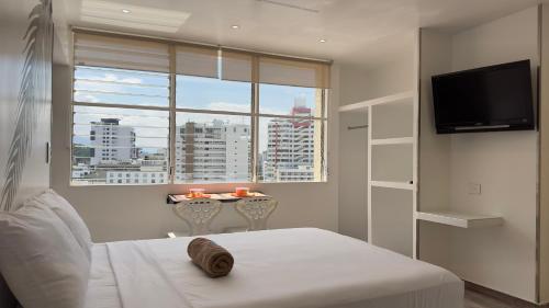 a bedroom with a bed and a window with a table at El Morro Beach 2 in Santa Marta