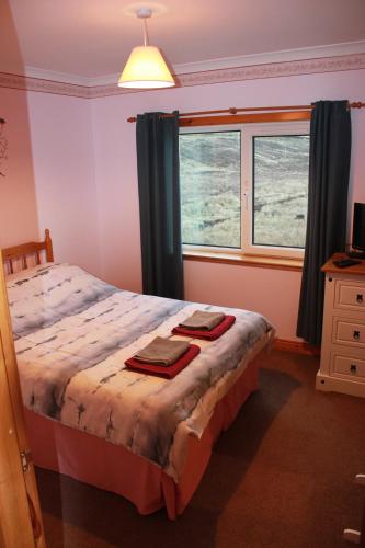 a bedroom with a bed with two towels on it at 73 Westend, Balallan, Isle of Lewis in Balallan