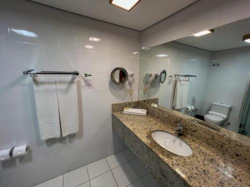 a bathroom with a sink and a mirror at Master Gramado Hotel - Espaço Kids Incrível in Gramado