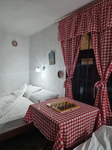 a bedroom with a table with a chess board on it at Apartmani kod Kmeta in Janja