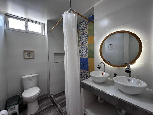 een badkamer met een toilet, een wastafel en een spiegel bij El Morro Beach 2 in Santa Marta