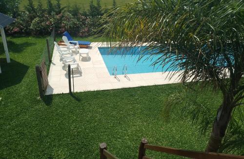 聖佩德羅的住宿－La Escapada San Pedro，享有带椅子和棕榈树的游泳池的顶部景致