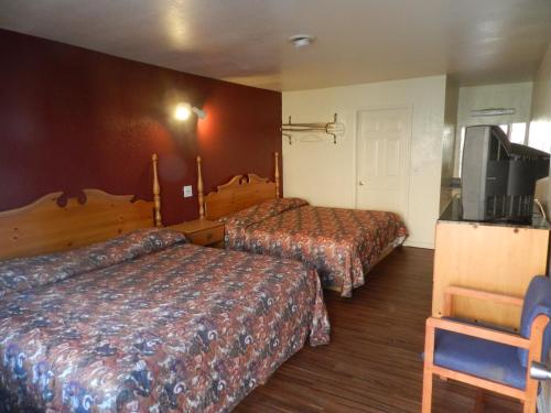 a hotel room with two beds and a flat screen tv at Seagem Motel and Apartments in Seaside Heights