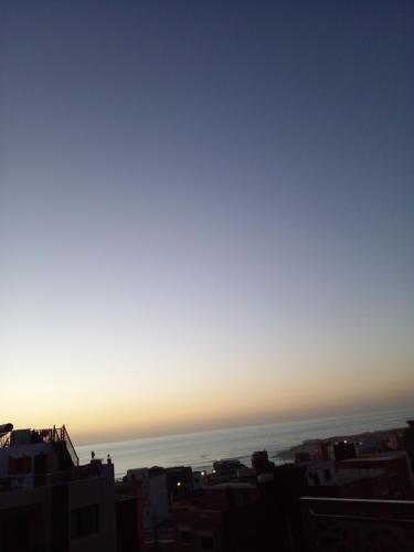 una vista del océano desde una ciudad al atardecer en Sun house, en Imsouane
