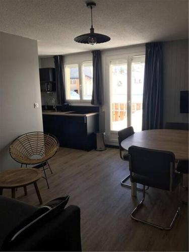 un salon avec une table et des chaises et une cuisine dans l'établissement Appartement Vue Montagne, à Val Louron