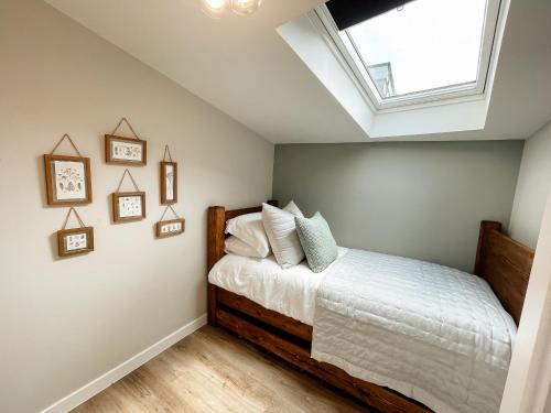 1 dormitorio con 1 cama y tragaluz en Otterburn House, en Rothesay