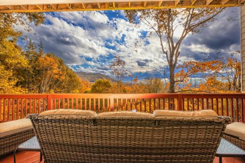 a patio with two wicker chairs on a deck at Hibernation Station - MTN Views near Asheville! in Swiss