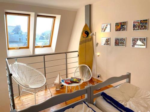 - une chambre avec un lit et une planche de surf sur le mur dans l'établissement Le Loft Cinéma Concarneau, à Concarneau