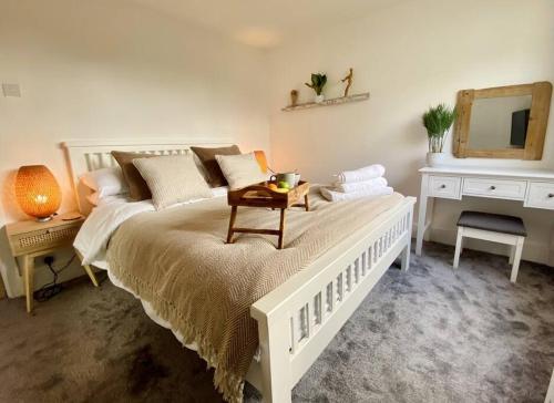 a bedroom with a bed with a table and a mirror at Tranquil Bridge Escape in Canterbury